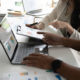 A group of people sitting at a table with laptops.