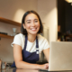 A woman sitting at a table with a laptop.