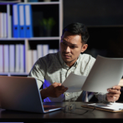 A man sitting at his desk looking at papers.