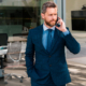 A man in a suit and tie talking on the phone.