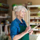 A woman in an apron holding a tablet.