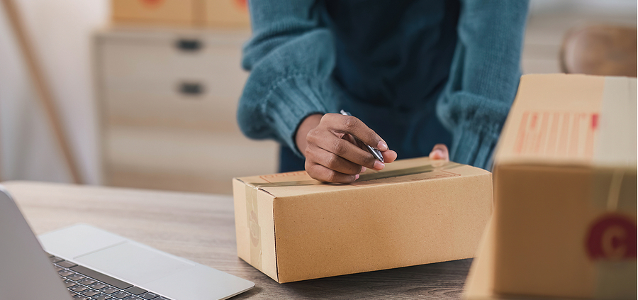 A person opening up a box on top of a table.