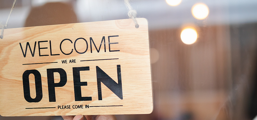 A wooden sign hanging in front of a window.