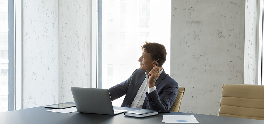 A man sitting at a table with a laptop.