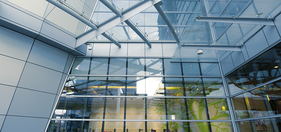 A large glass building with many windows and some lights